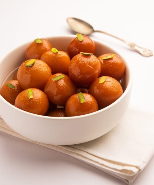 Indian sweet food Gulab Jamun served in a round ceramic bowl